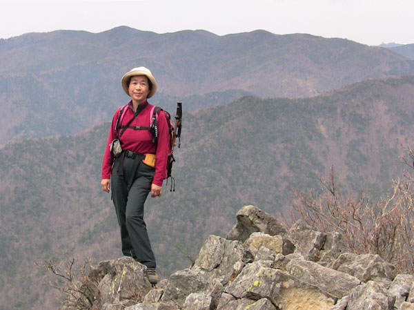photo：山頂に立つ、右奥に金峰山・乾徳山