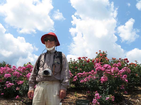 photo：千曲川のほとりでカメラを下げて立つ：さかき千曲川バラ公園